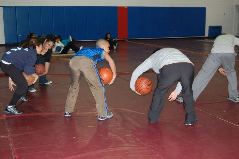 Mentoreados hacen un ejercicio de baloncesto en el gimnasio de la escuela.