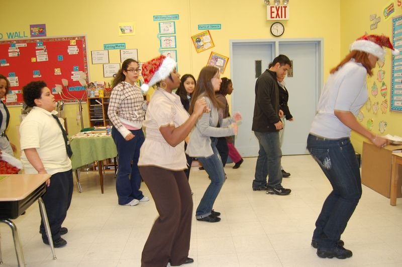 Mentores y mentoreados bailan en una celebración en el aula.
