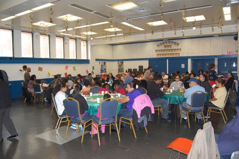 Un salón comunitario lleno de familias en un evento de BOOM.