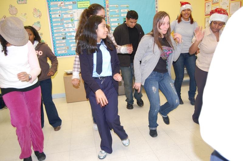 Mentores y mentoreados bailan en un aula decorada para las fiestas.