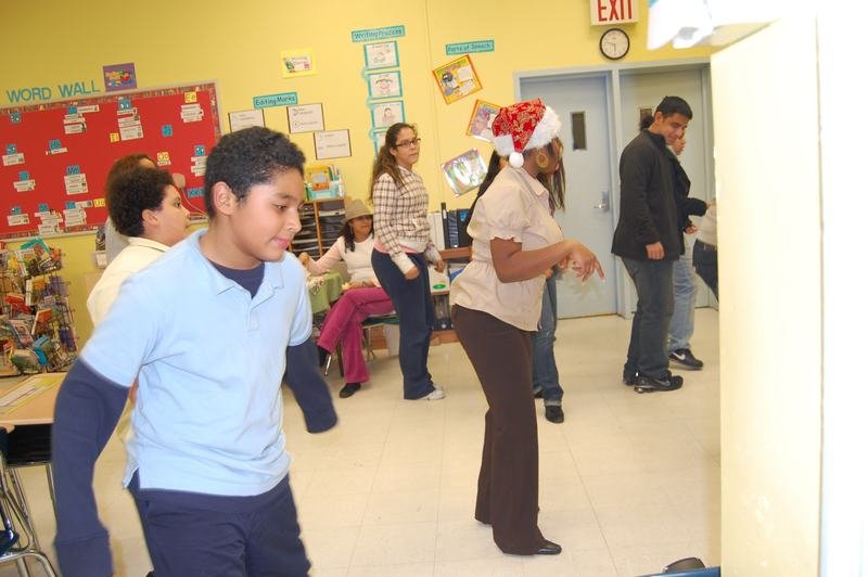 Una mentoreada baila en medio de una fiesta navideña en el aula.