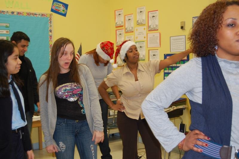 Personal del programa y mentoreados bailan juntos en la fiesta navideña del aula.