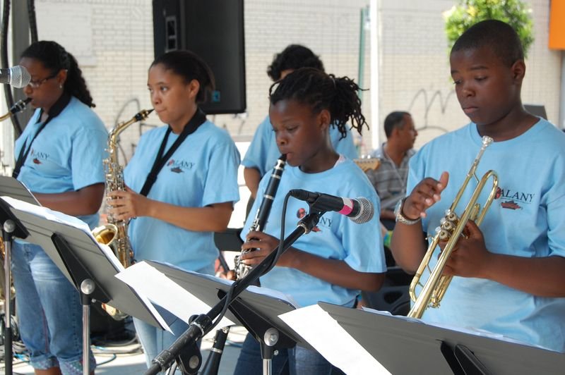 Jóvenes del programa tocan juntos saxofón, clarinete y trompeta.
